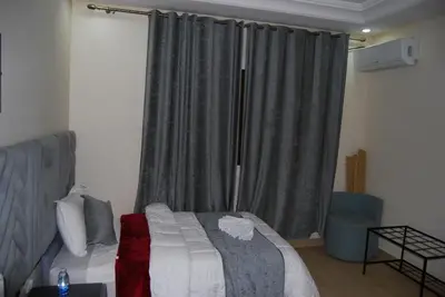 a bedroom with a bed and a window with curtains at Hotel la Perle d'Arfoud in Erfoud