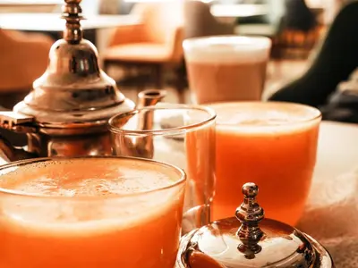 a table topped with two glasses of orange juice at Hotel la Perle d'Arfoud in Erfoud