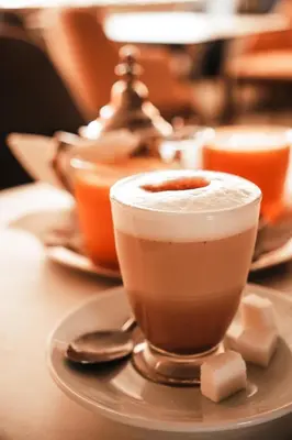 two cups of coffee sitting on a plate on a table at Hotel la Perle d'Arfoud in Erfoud