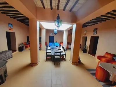 a dining room with a table and chairs in a room at Gite d'étape nomade in Tajda