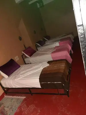 two twin beds in a room with red at Gite d'étape nomade in Tajda