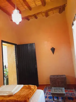 a bedroom with a bed and a black door at Gite d'étape nomade in Tajda