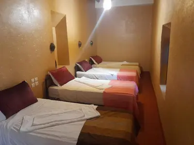 a hotel room with three beds in it at Gite d'étape nomade in Tajda