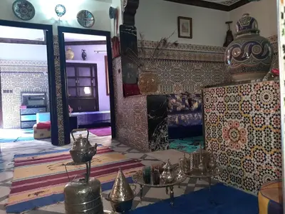 a living room with a fireplace and a tile wall at Riad Mini Batha Family Fez Chez ABBADI in Fès