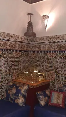 a room with a couch and a table with a cross on the wall at Riad Mini Batha Family Fez Chez ABBADI in Fès