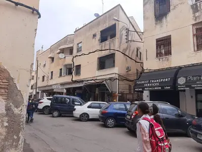 a street with cars parked on the side of a building at Riad Mini Batha Family Fez Chez ABBADI in Fès