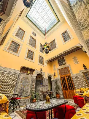 a room with a table and chairs and a ceiling at Riad Diamant De Fes in Fès