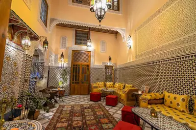 a lobby with yellow chairs and tables in a building at Riad Diamant De Fes in Fès