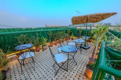 a patio with tables and chairs and potted plants at Riad Diamant De Fes in Fès