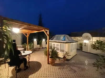 a patio with a table and a gazebo at night at Charmant appartement avec terrasse privee a fes medina in Fès