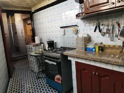 a kitchen with a stove and a counter top at Charmant appartement avec terrasse privee a fes medina in Fès