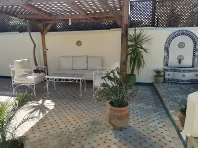 a patio with a couch and chairs and a table at Charmant appartement avec terrasse privee a fes medina in Fès