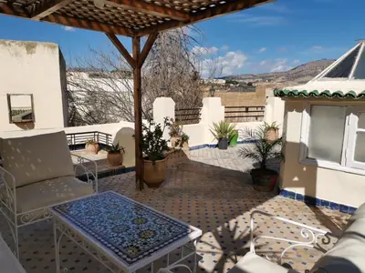 a patio with a table and chairs on a roof at Charmant appartement avec terrasse privee a fes medina in Fès
