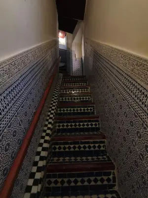 a set of stairs in a building with a checkered floor at Charmant appartement avec terrasse privee a fes medina in Fès