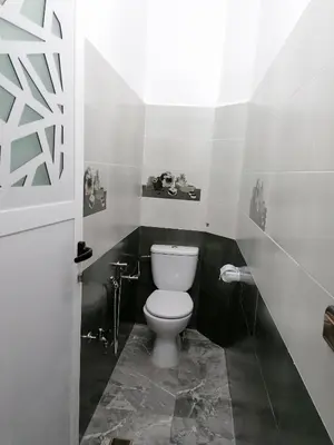 a bathroom with a white toilet in a room at Le bel abri in Meknès