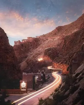 a winding road in a canyon with a mountain at Riad DAR outebba in Zaouïet Sidi Daoud