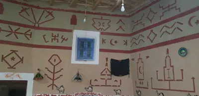 a room with a wall covered in art on it at Riad DAR outebba in Zaouïet Sidi Daoud