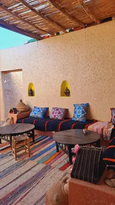 a living room with couches and tables in a room at LA PETITE MAISON DU LAC IRIKI in Foum Zguid