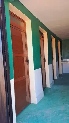 a row of doors in a room with green at LA PETITE MAISON DU LAC IRIKI in Foum Zguid