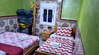 a bedroom with two beds and a window at Auberge Cascade Imilchil in Imilchil