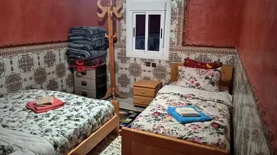 a bedroom with two twin beds and a mirror at Auberge Cascade Imilchil in Imilchil