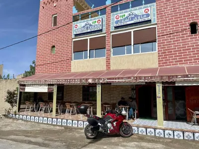 a red motorcycle parked in front of a building at Auberge Cascade Imilchil in Imilchil