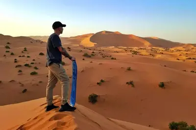 a man standing on a sand dune in the desert at Stargazing Merzouga Camp in Merzouga