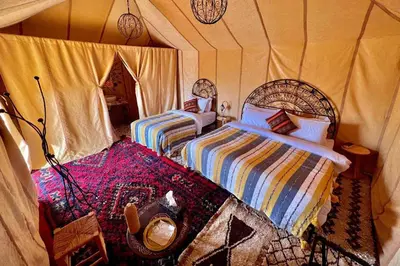 a bedroom with two beds in a tent at Stargazing Merzouga Camp in Merzouga