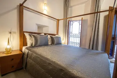 a bedroom with a bed with a wooden frame and a window at Riad Fes Elite in Fès