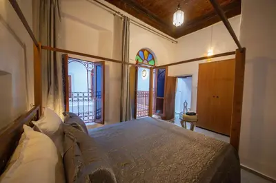 a bedroom with a bed in a room with a window at Riad Fes Elite in Fès