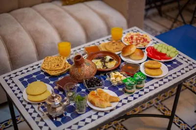 a tray of food on a table with plates of food at Riad Fes Elite in Fès