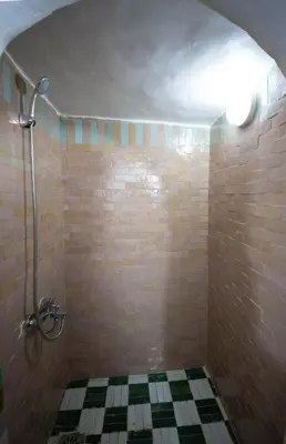 a bathroom with a shower with a tiled floor at Riad Fes Elite in Fès