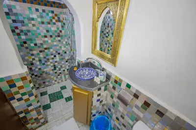 a bathroom with a mosaic sink and a mirror at Riad Fes Elite in Fès