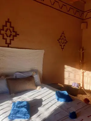 a bedroom with a bed with blue towels on it at Maison d'hôtes IZZA in Kalaat MGouna