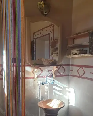 a bathroom with a sink and a mirror at Maison d'hôtes IZZA in Kalaat MGouna