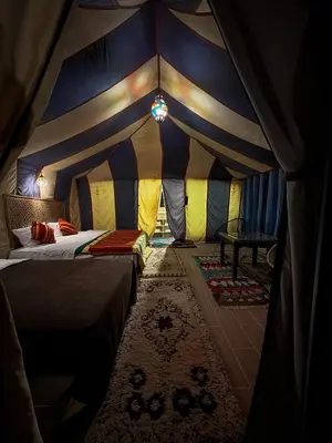 a room with a tent with a bed and a rug at Dream luxury camp in Merzouga