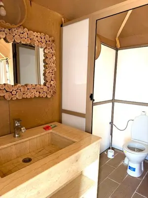 a bathroom with a wooden tub and a toilet at Dream luxury camp in Merzouga