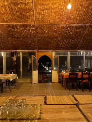 a restaurant with tables and chairs and a ceiling at Dream luxury camp in Merzouga