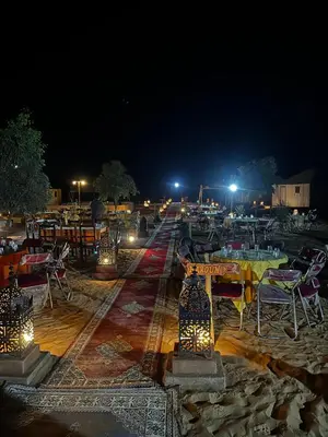 a group of tables and chairs at night at Dream luxury camp in Merzouga