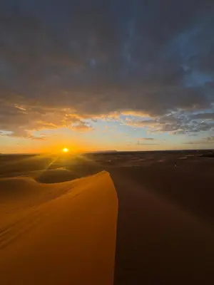 a sunset over the sand dunes in the desert at Dream luxury camp in Merzouga