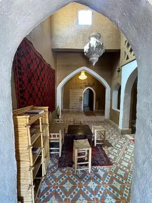 a room with a table and chairs and a ceiling at berber desert home for rent in Merzouga
