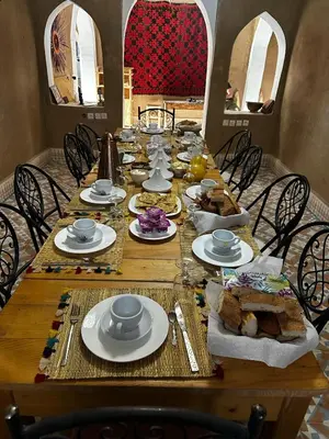 a long wooden table with plates of food on it at berber desert home for rent in Merzouga