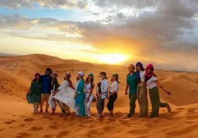 a group of people posing for a picture in the desert at Sunshine luxury tent in Merzouga