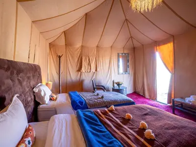 a bedroom with two beds in a tent at Authentic Desert Camp in Merzouga