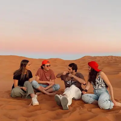 a group of people sitting in the desert at Authentic Desert Camp in Merzouga