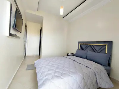 a bedroom with a large bed with blue pillows at Hotel La coline in Beni Mellal