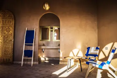 a room with two chairs and a table and a door at Riad Dar Tiziri in Zagora