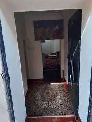 a hallway with a door leading into a room with a rug at Dar Sahara Ouarzazate in Ouarzazate