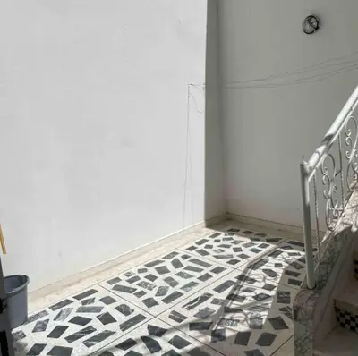 a staircase with a black and white tiled floor at Appartement 2 chambres avec lit bébé in Fès
