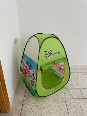 a green tent sitting on the floor next to a wall at Appartement 2 chambres avec lit bébé in Fès